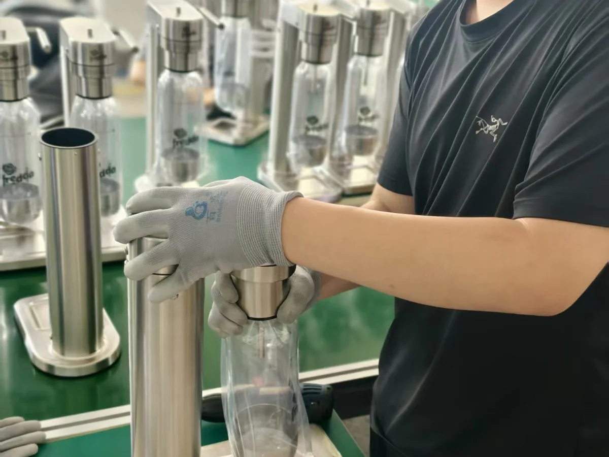 Worker fitting a bottle during G15 Pro soda maker assembly for Brazil