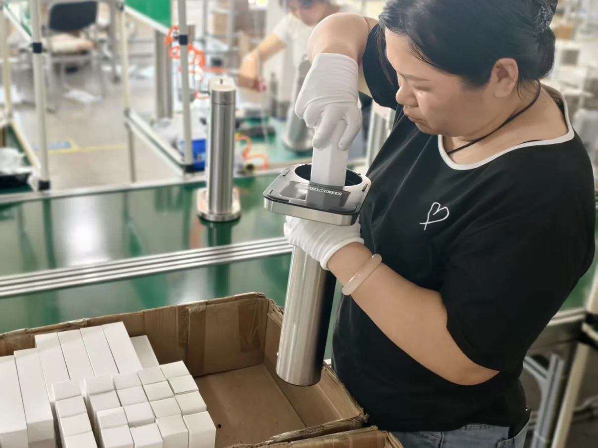 Worker assembling the upper section of a G15 Pro soda maker for the Brazil order